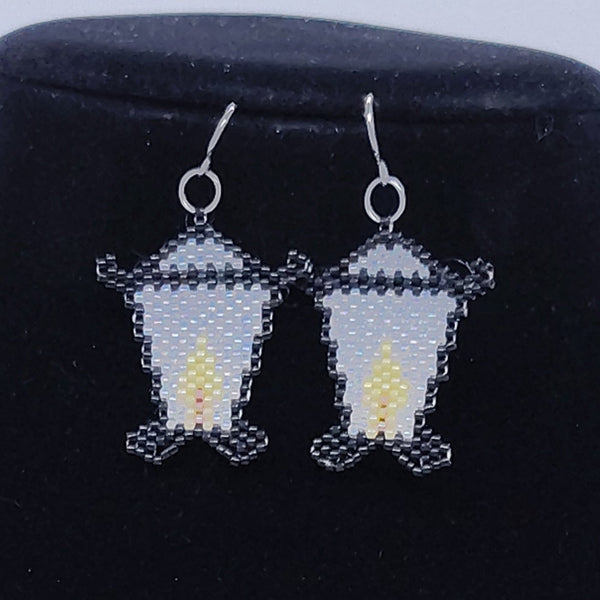 Black velvet jewelry display with earrings on a white background