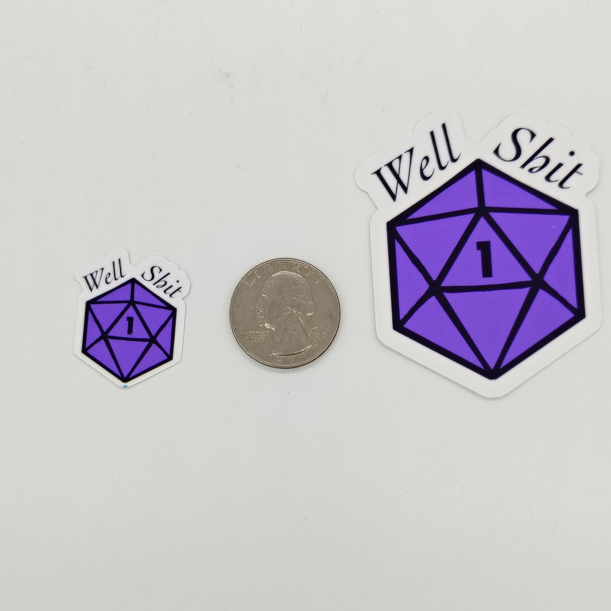 An image of 2 stickers, Purple D20 displaying a nat 1 and the words 'well shit' compared to a quarter in size