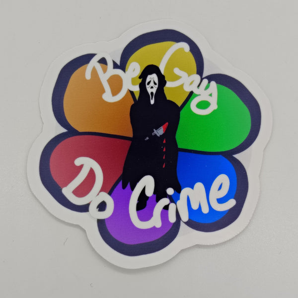 an image of a chibi version of ghost face over a background of a rainbow flower with the words be gay do crime